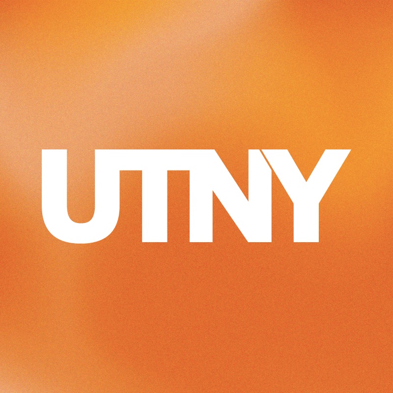 Letters UTNY in bold white on a cloudy orange background